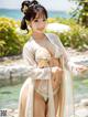 A woman in a white and gold kimono posing by the water.