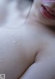 A close up of a woman's breast with water droplets on it.