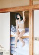 A woman in a white bikini sitting on a bunk bed.