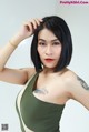 A woman with a tattoo on her arm is posing for a picture.