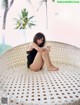 A woman sitting on top of a white wicker chair.