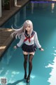 A girl in a school uniform standing next to a pool.