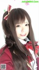 A girl with long brown hair wearing a red and white uniform.