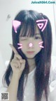 A girl with long black hair wearing a pink cat ears headband.