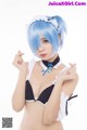 A woman with blue hair wearing a black and white bikini.