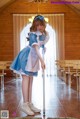 A woman in a blue and white dress is cleaning the floor.