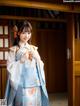 A woman in a blue and white kimono posing for a picture.