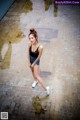 A woman standing in the middle of a puddle of water.